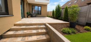 a garden with steps leading up to a house at Apartmán na Rohu I in Malacky