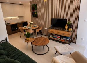 a living room with a television and a table and chairs at Apartmán na Rohu I in Malacky