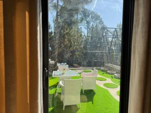 a view of a table and chairs from a window at Swiss Chalet Near Murree in Bhāngal