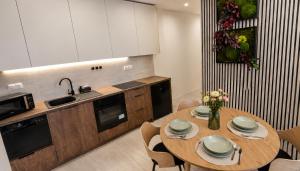 a kitchen with a table with chairs and a sink at Apartmán na Rohu I in Malacky