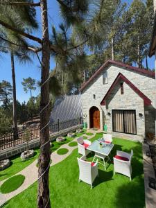a backyard with a table and chairs and a barn at Swiss Chalet Near Murree in Bhāngal