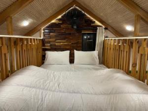 a bedroom with a large white bed in a cabin at Swiss Chalet Near Murree in Bhāngal +10 photos