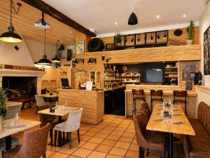 a restaurant with tables and chairs and a bar at Le Relais de la Calèche in Le Beausset