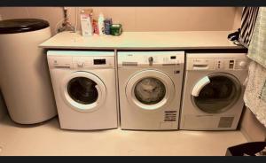 two washing machines and a washer and dryer in a kitchen at Otta Studio apartment in Sel