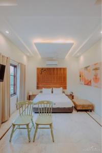 a bedroom with a bed and two chairs in it at Giovanni Suites in Bhopal