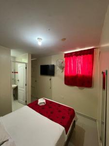 a bedroom with a bed with a red window at Hotel Inca Perú in Piura