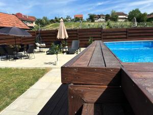 a wooden table sitting next to a swimming pool at Vila Jovanovic in Bajina Bašta +27 photos