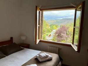 a bedroom with a bed and a large window at Hostería Bärenhaus in San Martín de los Andes
