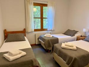 a room with three beds and a window at Hostería Bärenhaus in San Martín de los Andes +30 photos