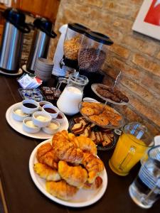 a table with plates of pastries and other breakfast foods at Hostería Bärenhaus in San Martín de los Andes
