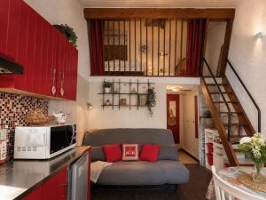 a living room with a couch in a kitchen at Cocooning Auvergnat in La Bourboule