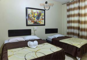 a room with two beds and a painting on the wall at Hotel Inca Perú in Piura +14 photos