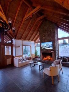 a large living room with a stone fireplace at Hostería Bärenhaus in San Martín de los Andes