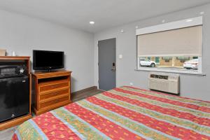 a bedroom with a bed and a flat screen tv at Village Lodge in Bristol