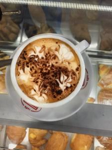 a cup of coffee sitting on a shelf with pastries at Roxy's Home In Rome in Rome +24 photos