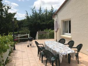 a patio with a table and chairs and a grill at La Surprise d'Elie - Espace et Calme proche plages - 3 chambres in La Boissière-des-Landes
