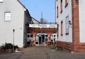 uma entrada para um edifício com mesas e cadeiras em Hotel-Gasthof-Destille-Eisenbahn em Mosbach