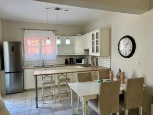 a kitchen with a table and a clock on the wall at Salve Suite in Lefkada