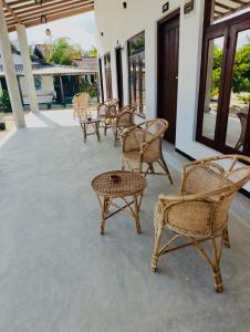 a group of chairs and tables on a patio at Jesoloresort Arugambay in Arugam Bay