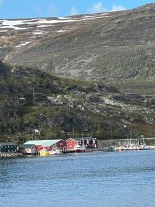 a red building in the middle of a body of water at Glassiglo for 2 in Russenes