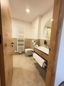 a bathroom with a toilet and a sink and a mirror at Apartmenthotel Rosentaler Hof Quartier2 in Pirk +43 photos