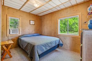 a bedroom with a bed and two windows at Cabin #9 2BR 1BA Timberlane Resort in Park Rapids