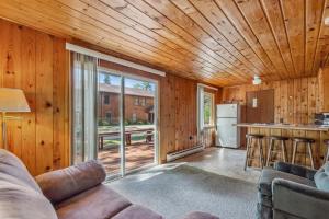 a living room with a couch and a kitchen at Cabin #10 2BR 1BA Timberlane Resort in Park Rapids