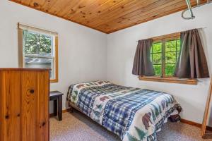 a bedroom with a bed and a window at Cabin #10 2BR 1BA Timberlane Resort in Park Rapids