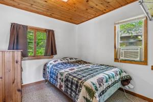 a bedroom with a bed and two windows at Cabin #10 2BR 1BA Timberlane Resort in Park Rapids