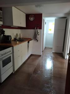 a kitchen with white cabinets and a white stove at Kleiner Fuchsbau in Kleinern +9 photos
