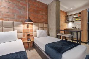 two beds in a small room with a kitchen at Appartments Pool and Rooftop Downtown Hotel in Medellín +42 photos