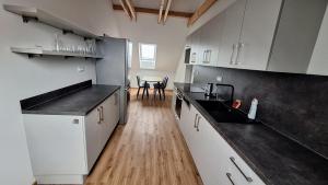 a kitchen with white cabinets and a wooden floor at Thomas home in Homole