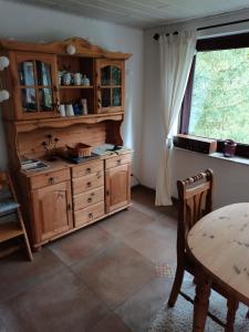 a kitchen with wooden cabinets and a table and a window at Kleiner Fuchsbau in Kleinern