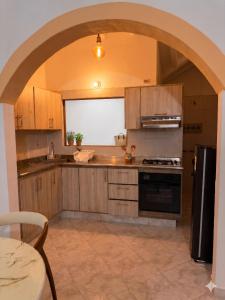 a kitchen with wooden cabinets and an archway at Casa Hotel Cenit in Villa de Leyva +23 photos