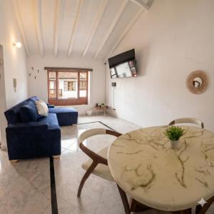 a living room with a table and a blue couch at Casa Hotel Cenit in Villa de Leyva