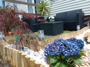 a garden with blue flowers in a fence at Casa Nature's Avlis Bungalow 4XZ in Pataias