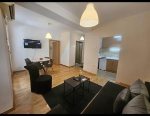 a living room with a couch and a table at Lovely square apartment Purple Velvet 43 Macedonia Stree in Skopje +3 photos