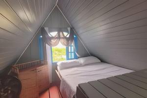 a small bedroom with a bed and a window at Chalé frente mar na Ilha do Mel - Encantadas. in Ilha do Mel