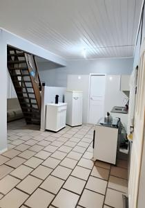 a kitchen with white appliances and a staircase at Chalé frente mar na Ilha do Mel - Encantadas. in Ilha do Mel