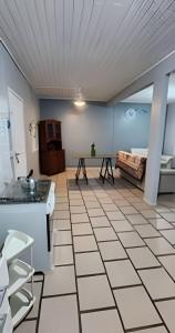 a room with a white tile floor and a table at Chalé frente mar na Ilha do Mel - Encantadas. in Ilha do Mel