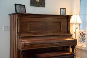 a large wooden piano in a room with a lamp at Bella Di Lago in Wilkesboro