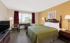 a hotel room with a bed and a flat screen tv at Lincoln Way Inn in Chambersburg