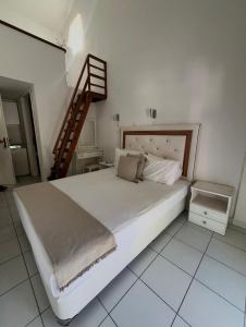 a bedroom with a large white bed and a staircase at Villa Apostolidis in Skala Potamias +4 photos