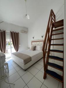 a white bedroom with a bed and a staircase at Villa Apostolidis in Skala Potamias