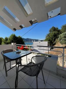 a table and chairs on a balcony with a view at Villa Apostolidis in Skala Potamias