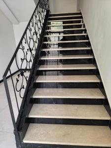 a staircase with a black and white railing at Appartement nador G in Nador +3 photos