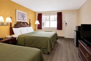 a hotel room with two beds and a flat screen tv at Lincoln Way Inn in Chambersburg