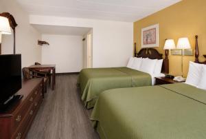 a hotel room with two beds and a flat screen tv at Lincoln Way Inn in Chambersburg