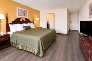 a hotel room with a bed and a flat screen tv at Lincoln Way Inn in Chambersburg +3 photos