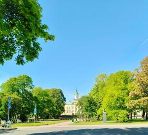 a building with a clock tower in the middle of a park at Gallen-Kallelankatu 9 in Pori
